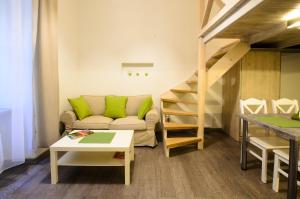 a living room with a couch and a staircase at Apartamenty Winnicy Kresy II in Krakow