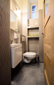 a bathroom with a white toilet and a sink at Apartamenty Winnicy Kresy II in Krakow