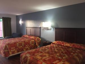 Кровать или кровати в номере Gulf American Inns