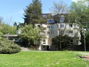 un grand immeuble d'appartements avec une pelouse devant lui dans l'établissement Jugendherberge Freiburg, à Fribourg-en-Brisgau