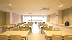 an empty lecture room with tables and chairs at Hotel Premium Green Plus in Sendai