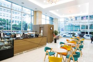 a restaurant with tables and chairs and windows at Ramada by Wyndham Jeju City Hall in Jeju