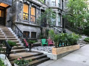 a house with chairs and stairs in front of it at Ambrose House & Cafe - SELF CHECK-IN GUESTHOUSE in Montreal