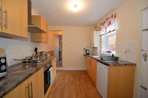a kitchen with wooden cabinets and a counter top at Hyde Park Apartment in Gateshead