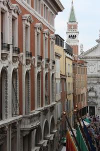 una calle de la ciudad con edificios y una torre del reloj en Ca' Pedrocchi en Venecia