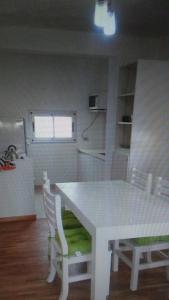 cocina con mesa blanca y sillas blancas en Temporario 42 en La Plata