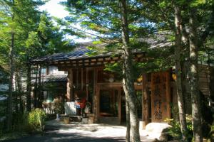 a small house in the middle of trees at Shibu Tatunokan in Chino