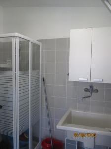 uma casa de banho com um lavatório e uma cabina de duche em vidro. em villetta al mare punta braccetto em Punta Braccetto