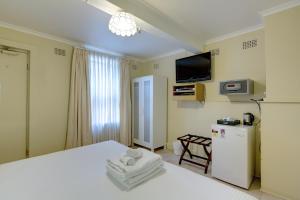 Habitación de hotel con 2 camas y nevera. en Neutral Bay Lodge, en Sídney
