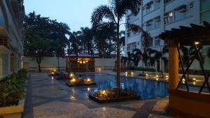 a courtyard with a pool with candles and a building at Suntrust Parkview Apartment in Manila