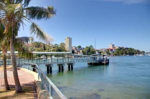 a bridge over a river with palm trees and a city at Neutral Bay Lodge in Sydney