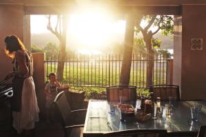 a woman and a child standing next to a table at Wooli Holiday Units in Wooli