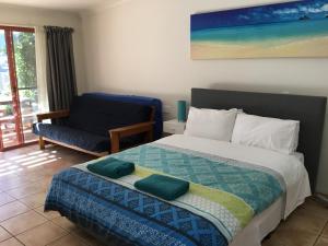 een slaapkamer met een groot bed en een stoel bij Byron Beach House in Byron Bay
