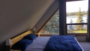 a bed in a room with a large window at Wettstone Guest Ranch in Bridge Lake