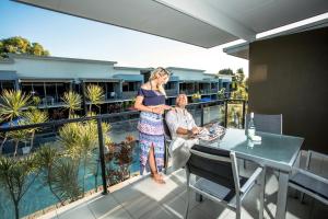 a woman standing on a balcony with a man at Ramada by Wyndham Hervey Bay in Hervey Bay
