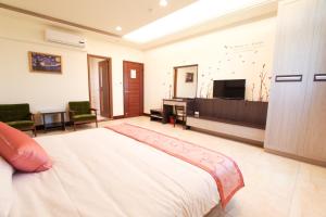 a bedroom with a bed and a flat screen tv at Long Xing B&B in Huxi