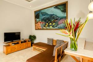 a living room with a large painting on the wall at Laba Ubud Villa in Ubud