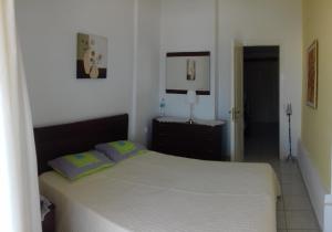 a white bedroom with a bed with two pillows at SeeTheSea Apartment Kanali in Preveza