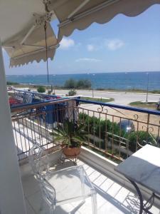 a balcony with a table and chairs and the ocean at SeeTheSea Apartment Kanali in Kanali