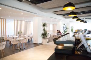ein Restaurant mit Tischen und Stühlen und Menschen, die an den Tischen sitzen in der Unterkunft Planet Hotels ONE - Adults Only 16 years in El Arenal