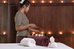 a woman standing in front of a cake with towels at Maison Dalabua in Luang Prabang