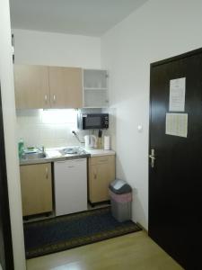 a small kitchen with a sink and a black door at Studio Apartments Ivica in Primošten