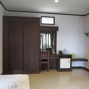 a hotel room with a desk and a door with a mirror at Needa Rock Resort in Khanom