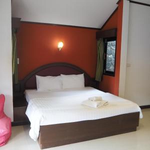 a bedroom with a large bed with white sheets at Needa Rock Resort in Khanom