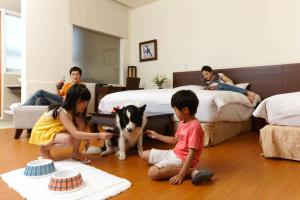 a group of children playing with a dog in a bedroom at LIDO FORESTRY SPA RESORT in Yangmei