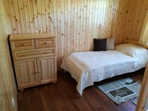 Un dormitorio con una cama y una pared de madera. en Faház, en Tiszaszőlős