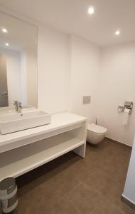a bathroom with a toilet, sink and bathtub at Planet One Hotel in El Arenal