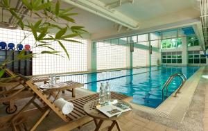 LIDO FORESTRY SPA RESORT في Yangmei: حمام سباحة كبير مع طاولة خشبية و منضدة sidx