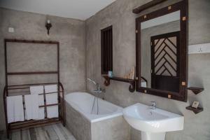 a bathroom with a sink and a tub and a mirror at Villa Pinnawala & Restaurant in Pinnawala