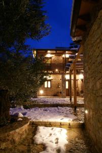 una casa con nieve delante de ella por la noche en Argyriou Wine Tasting Guest House en Polydrossos