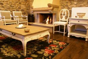 a living room with a fireplace and a table and chairs at Argyriou Wine Tasting Guest House in Polydrossos