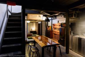 a kitchen with a wooden table and a kitchen with a staircase at Kyoto Gojo Samurai Machiya in Kyoto