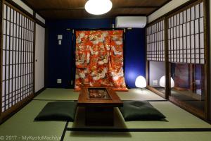 a living room with a table and a large curtain at Kyoto Gojo Samurai Machiya in Kyoto