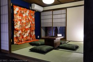 a room with a table and a wall with a curtain at Kyoto Gojo Samurai Machiya in Kyoto