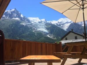 una mesa y una sombrilla en un balcón con montañas en La Para en Chamonix-Mont-Blanc