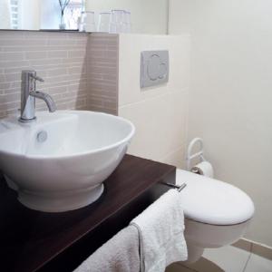 ein weißes Bad mit einem Waschbecken und einem WC in der Unterkunft Gästehaus Garni Sebastian 1520 in Rech