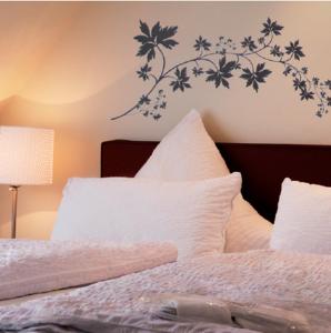 ein Schlafzimmer mit einem Bett mit Blumen an der Wand in der Unterkunft Gästehaus Garni Sebastian 1520 in Rech
