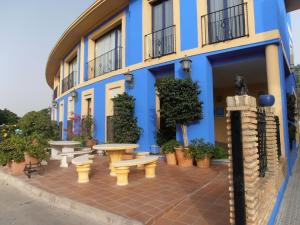 a blue building with benches in front of it at Hotel Caballo Negro in Puerto Real
