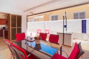 a dining room with a table and red chairs at Villa Xavier in Can Picafort