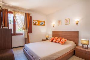 a bedroom with a bed with orange pillows and a window at Villa Xavier in Can Picafort