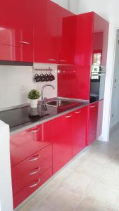 - une cuisine rouge avec un évier et des placards rouges dans l'établissement Lovely Bungalow, à Maspalomas