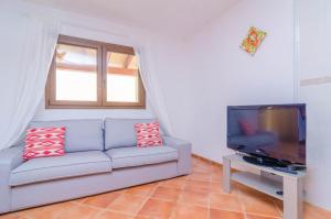 a living room with a couch and a flat screen tv at Sa Caseta De Ses Vaques. Son Covas (Sa Vaqueria 2) in Campos