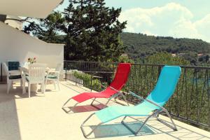 2 chaises et une table sur un balcon dans l'établissement Apartment Durdica, à Pučišća