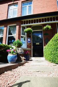 a brick house with two large pots of flowers in front of the door at Heathfield Bed and Breakfast in Whitby