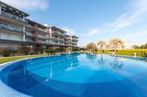 a large blue swimming pool in front of a building at Poema in Oliva