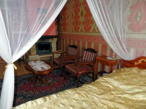 a bedroom with a bed and two chairs and a fireplace at Agroturystyka Zacisze in Osowia